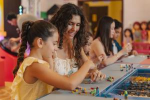 a woman and two children playing a game with beads at LEGOLAND Hotel Dubai in Dubai +82 photos