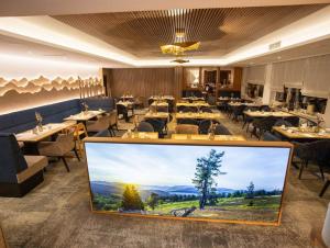 a restaurant with a large screen in the middle of the room at Göbels Landhotel in Willingen