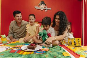 a family sitting on a bed with a piece of cake at LEGOLAND Hotel Dubai in Dubai