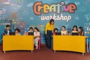 a woman standing in front of a group of children using computers at LEGOLAND Hotel Dubai in Dubai
