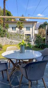 a patio table with two chairs and a plant on it at Cavigliano Rustico - free parking in Cavigliano