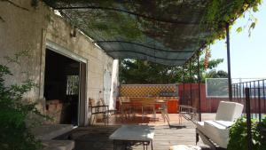 a patio with a table and chairs and a building at Villa Sant Antone in Ghisonaccia