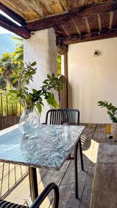 a glass vase sitting on a table with a plant at Cavigliano Rustico - free parking in Cavigliano