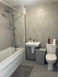 a bathroom with a sink and a toilet and a bath tub at Waverley 3-Bed Springfields House in Rotherham +16 photos