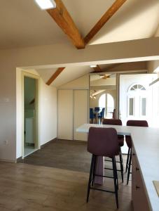 an open kitchen and dining room with a table and chairs at Pure Sky Apartments - with pool in Mostar +133 photos