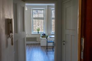 a hallway with a chair and a table and a window at Grand Jugend Studio in Kallio in Helsinki +6 photos