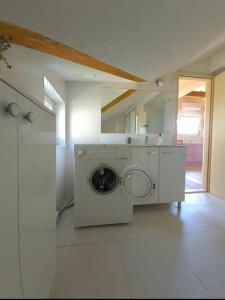 a washer and dryer in a white laundry room at Pure Sky Apartments - with pool in Mostar