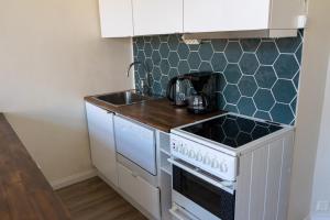 a kitchen with a white stove and a sink at Grand Jugend Studio in Kallio in Helsinki