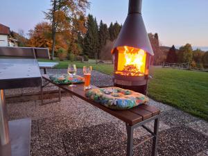 a fire pit with two wine glasses and a table at Waldhaus Flammersberger in Spiegelau