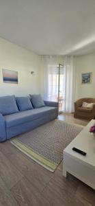a blue couch in a living room with a table at Casa Mar in Costa da Caparica