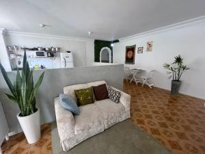 a living room with a couch and a kitchen at Quarto privado a 160 metros da Praia do Farol da barra 1 in Salvador +20 photos
