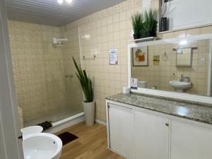 a bathroom with a sink and a toilet and a tub at Quarto privado a 160 metros da Praia do Farol da barra 1 in Salvador