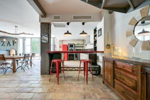 a kitchen and dining room with red stools at La Pause Camarguaise in Saint-Laurent-dʼAigouze