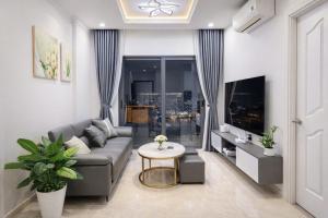 a living room with a couch and a table at Monarchy Luxury Serviced Apartments - By Charm Homestay Vietnam in Danang