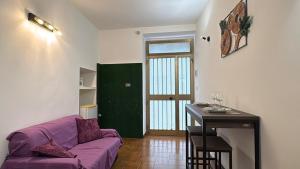 a living room with a purple couch and a table at Casa Vacanze "La Casetta" in Configni