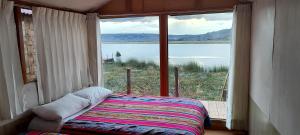 a bed in a room with a large window at Los Uros in Puno