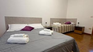a bedroom with two beds with purple and white towels at Casa Vacanze "La Casetta" in Configni