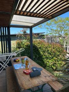 a wooden table sitting on a deck with a picnic table at Camping Paradis l'Arada Parc in Sonzay