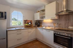 a kitchen with white cabinets and a window at Wildblick Appartment Hof Grindelborn in Mürlenbach