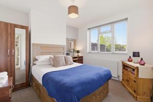 a bedroom with a bed with a blue blanket at 4BR with Private Parking in Wyken