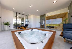 a large bath tub in a living room with furniture at Villa Aurora mit Sauna und Whirlpool in Dranske