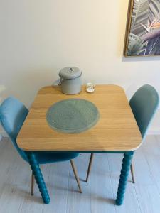 a wooden table with two chairs and a bowl on it at Parrot House in Bertinoro