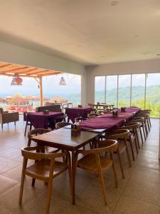 a row of tables and chairs in a room with windows at MeZZO Villa in Ayah