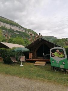 a group of people sitting in a car parked in front of a tent at Camping Onlycamp Les Peupliers du Lac in Chindrieux