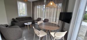 a living room with a couch and a table and chairs at Vakantiewoning Seehouse in Oostkapelle +5 photos