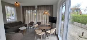 a living room with a couch and a table and chairs at Vakantiewoning Seehouse in Oostkapelle
