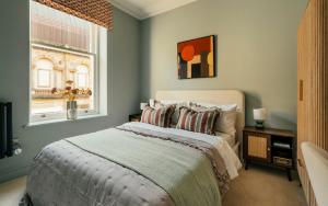 a bedroom with a bed and a window at St James Apartments - Harrogate in Harrogate