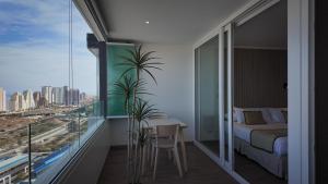 a bedroom with a balcony with a bed and a table at Marina Dunas in Viña del Mar