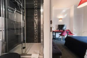 a room with a shower with a bed and a table at Hotel Mondial in Tours +276 photos