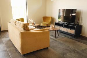a living room with a couch and a flat screen tv at Huisje Meersen in Maldegem