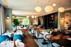 a restaurant with tables and chairs and lights at Le Manoir Hôtel Le Touquet Paris Plage in Le Touquet-Paris-Plage