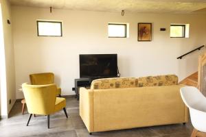 a living room with a couch and a tv at Huisje Meersen in Maldegem