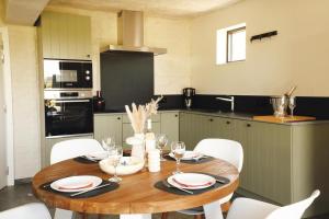 a kitchen with a wooden table and white chairs at Huisje Meersen in Maldegem +21 photos