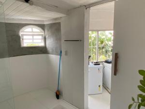 a bathroom with a mop and a window at Quarto com varanda privada a 160 metros da Praia do Farol da barra 3 in Salvador
