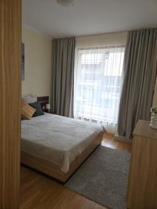 a bedroom with a bed and a large window at Marina Park OLIWIA in Sveti Vlas