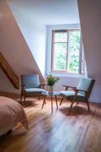 a bedroom with two chairs and a table and a window at La Pépite in Margut