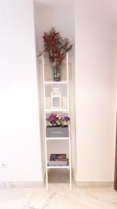 a white shelf with a vase of flowers on it at Hipalis Palmera in Seville