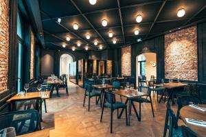 a restaurant with tables and chairs and brick walls at Bienheureux Hôtel & Restaurant in Wasquehal