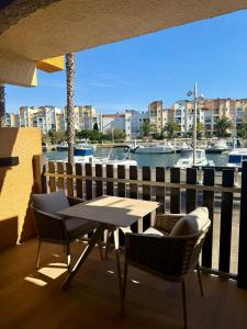 a table and chairs on a balcony with a marina at Bernard l'Hermite Studio in Gruissan