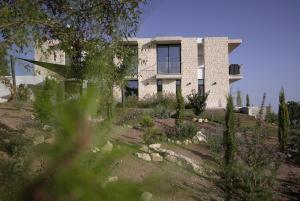 a building on top of a hill with a yard at Stylish Villa, Rural Setting, Infinity Pool in Pano Akourdalia