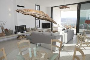 a living room with a couch and chairs and a tv at Stylish Villa, Rural Setting, Infinity Pool in Pano Akourdalia