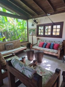 a living room with couches and chairs and windows at Hotel Pousada Cavalo Marinho in Boicucanga