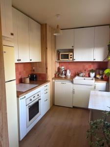 a kitchen with white cabinets and white appliances at Maison La Séréna in Arès