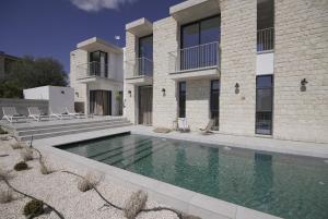 a swimming pool in front of a house at Stylish Villa, Rural Setting, Infinity Pool in Pano Akourdalia