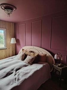 a bedroom with a large bed with pink walls at Maison La Séréna in Arès