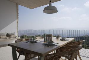 a table and chairs on a balcony with a view at Stylish Villa, Rural Setting, Infinity Pool in Pano Akourdalia